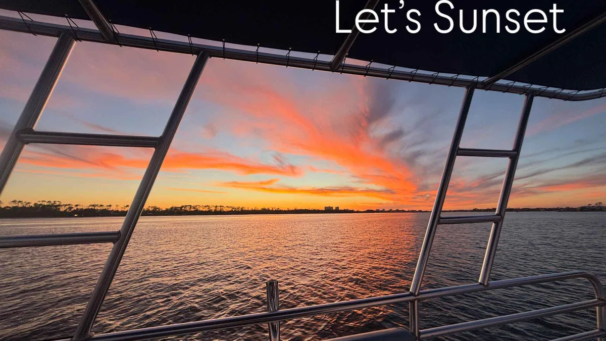 A pontoon boat with guests at sunset on a Shell Island dolphin tour from Panama City Beach, Florida