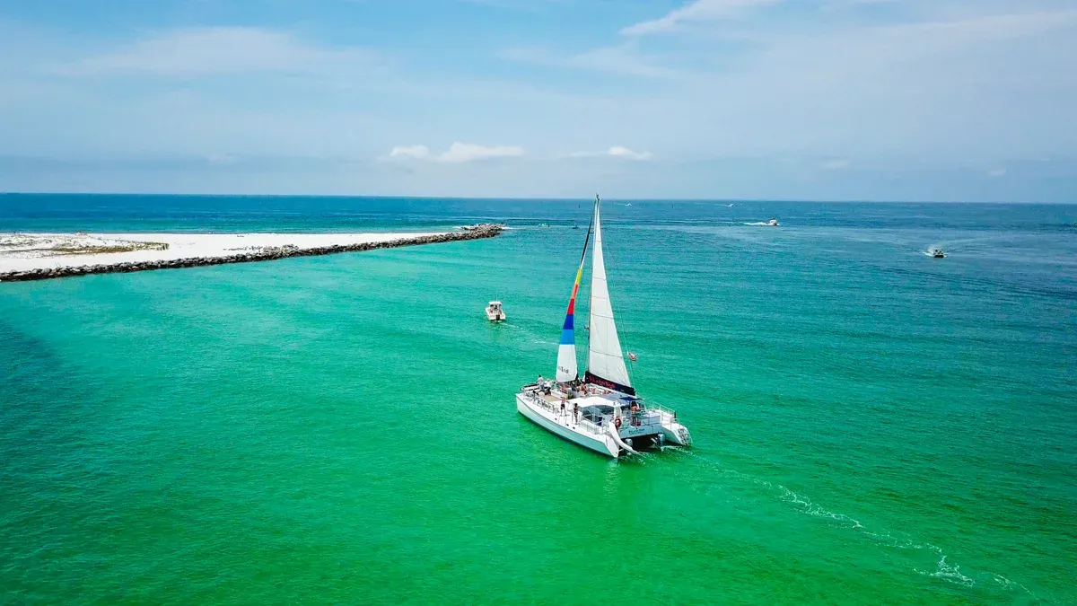 The Island Time sailing catamaran heading for the white sand tip of Shell Island, the boat used on this Shell Island dolphin tour from Panama City Beach, Florida